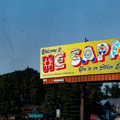 Photo of billboard framed by Black Hills landscape
