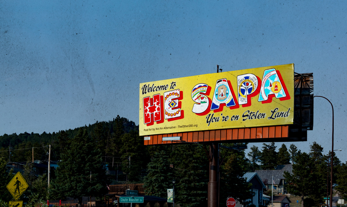 Photo of billboard framed by Black Hills landscape
